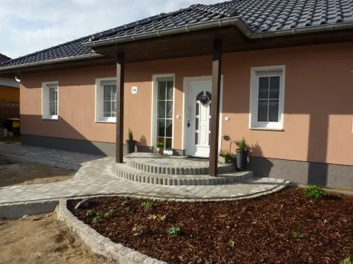 Neu gestalteter Hauseingang mit Pflasterung und Bepflanzung