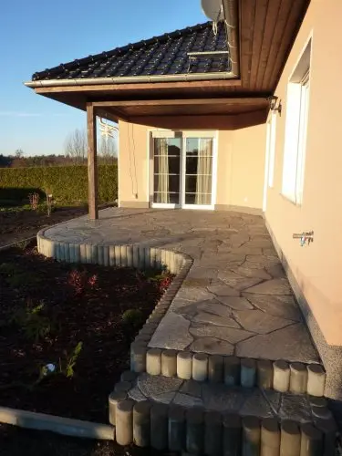 Gepflasterte Terrasse mit Stufen am Wohnhaus