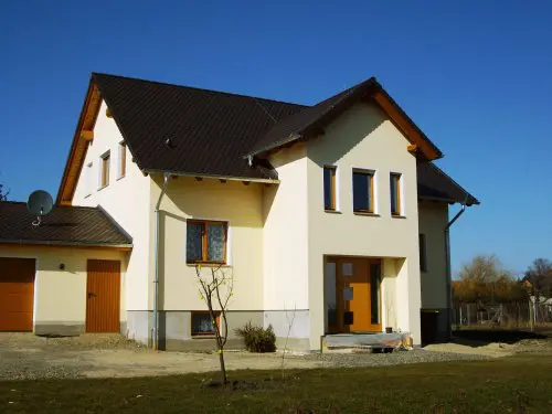 Neu gebautes Einfamilienhaus mit gelber Fassade und Satteldach