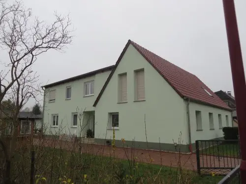 Umgebautes Wohnhaus mit heller Fassade und Satteldach
