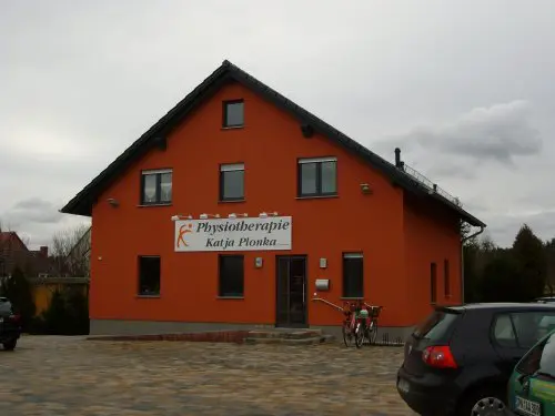 Wohn- und Geschäftshaus mit orangefarbener Fassade