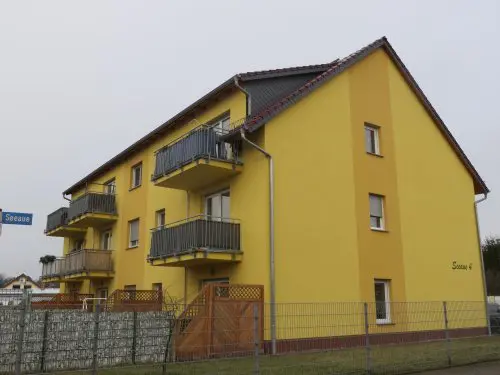 Mehrfamilienhaus mit gelber Fassade und Balkonen